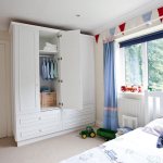 White wardrobe with an open door in a boy&#39;s room